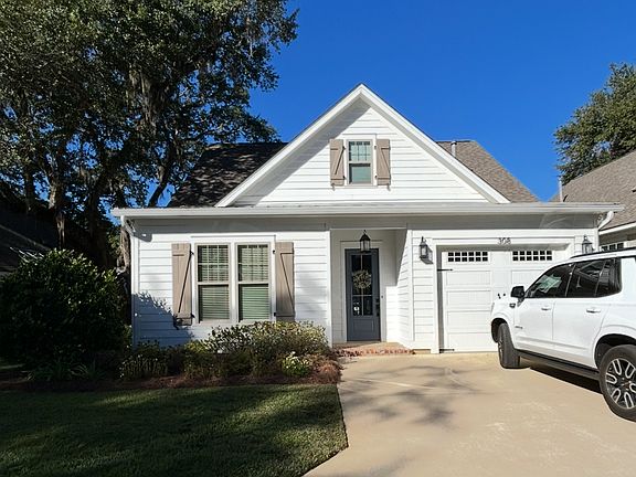 Cottage style condo living with single car garage and parking for 2 in driveway.