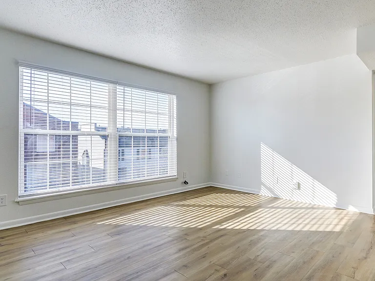 A bright living room with vinyl floor is shown at ReNew on Cantrell.