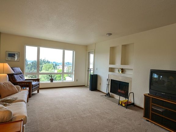 This is a HUGE Living area ~ you won't see any larger in this price range in Bellevue ! Beautiful New Carpets, insulated windows that open for fresh air. One of 2 doors to the private terrace. Wood Fireplace too ! 
