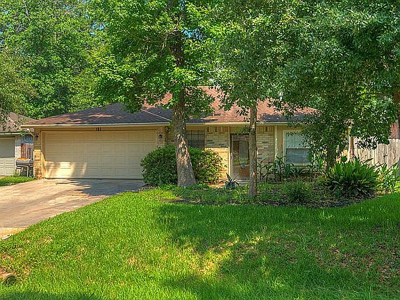 Large front yard with mature vegetation.