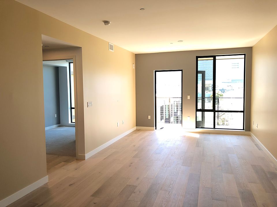 The living room with a private balcony at the far end which overlooks courtyard