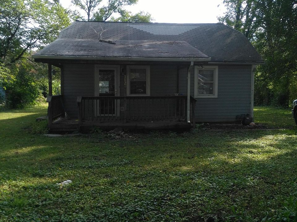 Deck off the front of the house. Driveway to the right.