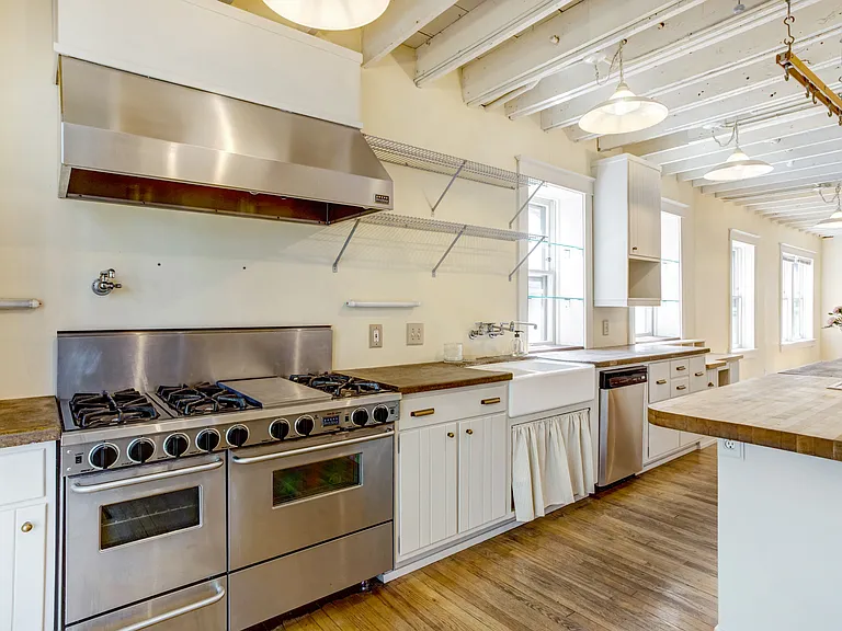 Kitchen. 5 star range with double oven, hood with heat lamps, and a pot filler over the stove.