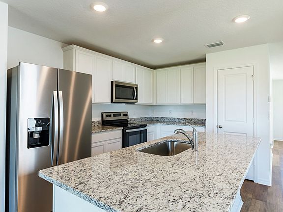 The kitchen is chef-ready with stainless steel appliances