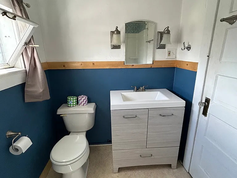 Welcome to the bathroom that's small but mighty! It's got a toilet, a narrow mirror cabinet (perfect for skinny things), and a cozy vanity. Compact, efficient, and proof that great things really do come in small packages. Time to embrace the snug life!