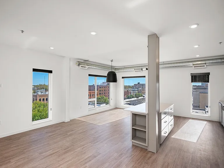 Bright and spacious modern apartment with open-concept design, large windows offering city views, and sleek wooden flooring. Bright and spacious modern apartment with open-concept design, large windows offering city views, and sleek wooden flooring.