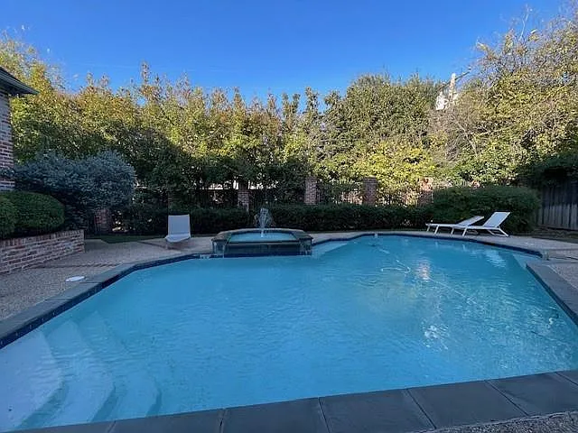 View of swimming pool featuring a patio area and a pool with connected hot tub