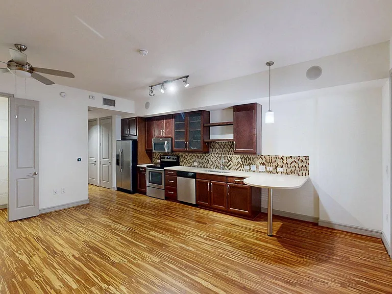Apartment Kitchen with Quartz counter tops and Wood Style Flooring.