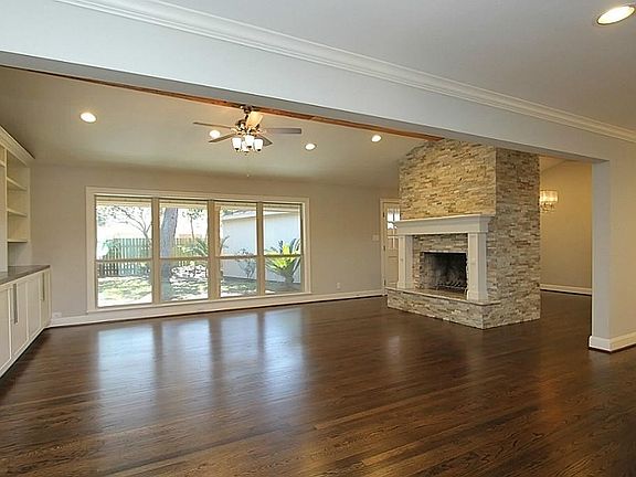 Spacious Den/Living has amazing stone fireplace, custom built in cabinets, recessed lighting, framed
