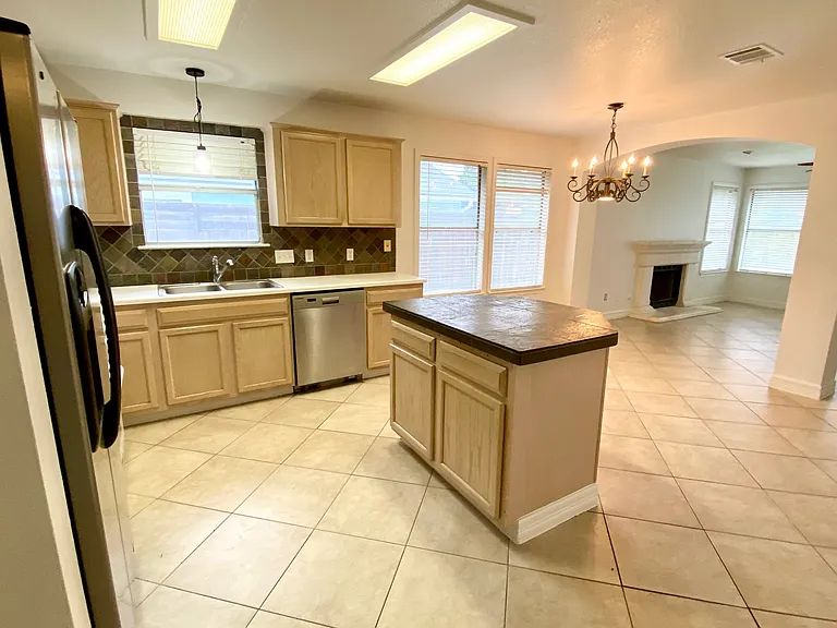 Kitchen with small island for additional storage and seating along with a breakfast eating area. All open to family room with arches.