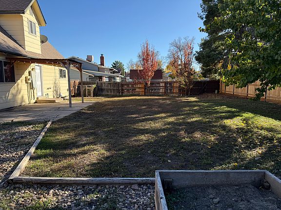 View of back yard from the raised bed area; privacy fence extends around whole back yard.