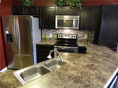 Open kitchen concept to LR and Dining Rm., 'espresso' stained cabinets, has new tile backsplash and all stainless steel appliances!