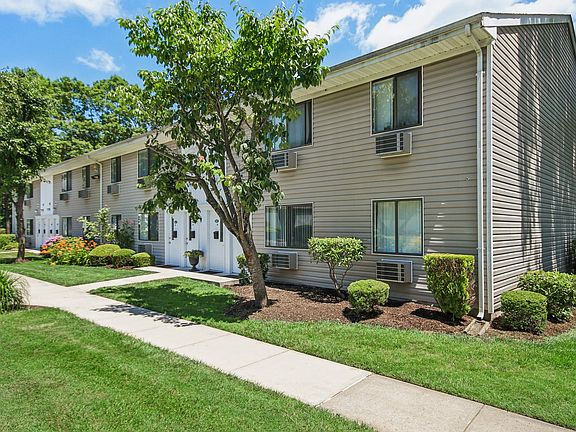 Outside view of apartment with a sidewalk and trees in front