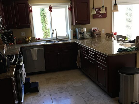 Beautiful kitchen with stone floors, granite countertops, gas range, stainless steel appliances.