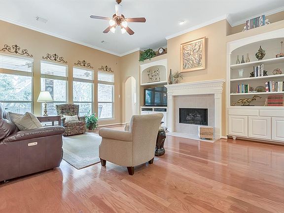 Family Room has beautiful wood floors, custom built-ins, crown molding, gas log fireplace, and windows that fill the room with natural light.