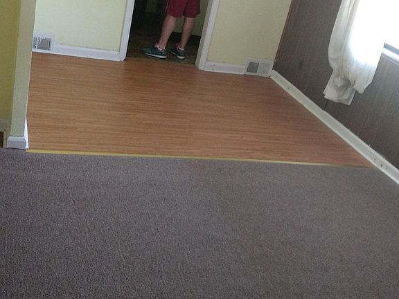 Carpeted living room and wooded dining room