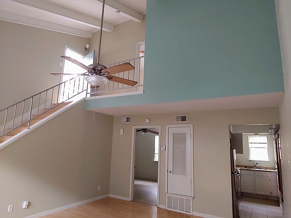 Living room with the kitchen to the right and downstairs bedroom to the left. The access to the private terrace is from the landing.