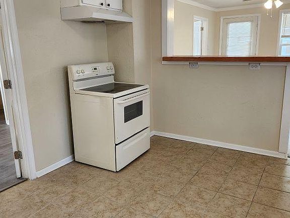 Kitchen with stove, hood and storage.