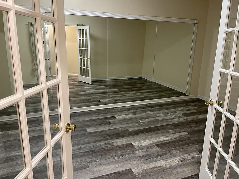Large room with french doors and mirror wall on main floor.