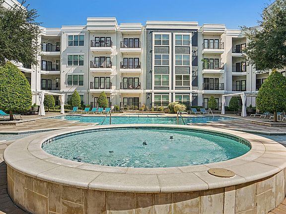 Resort-style swimming pool surrounded by lounge chairs at Addison Keller Springs in Addison, Texas