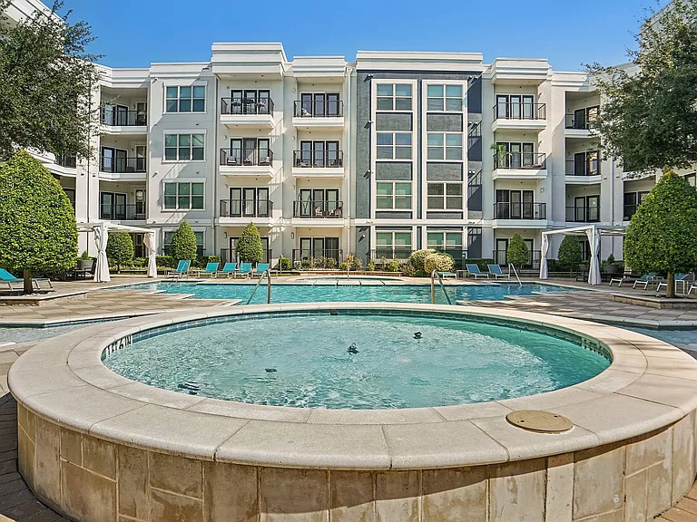 Resort-style swimming pool surrounded by lounge chairs at Addison Keller Springs in Addison, Texas