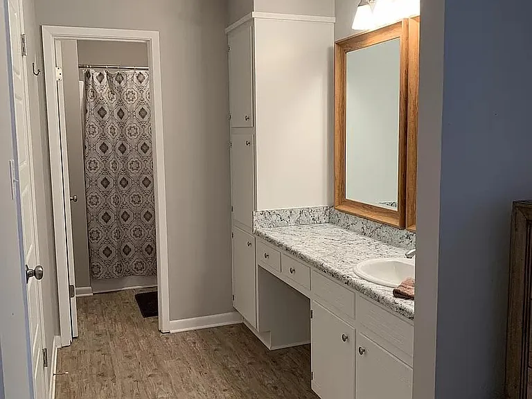 Master bath with vanity, 2 large framed mirrors and lots of storage space with linen closet, drawers and cupboards