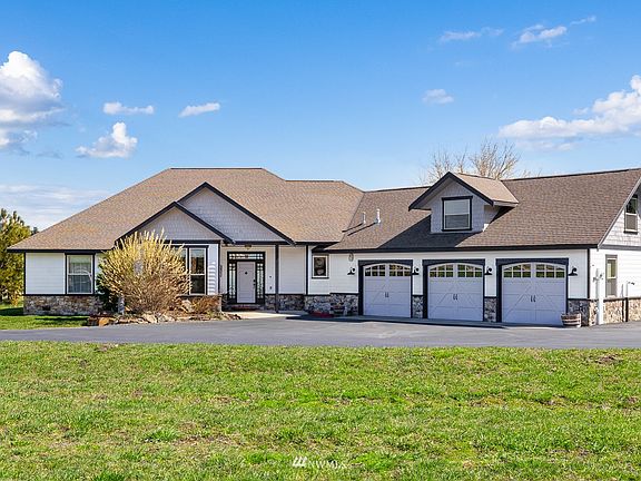 The paved driveway leads to the attached 3 car garage.