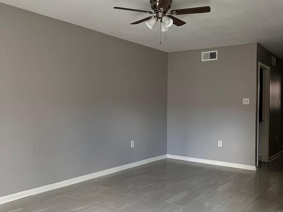 Living room is freshly renovated with new ceramic tile floors and freshly painted grey 
walls.