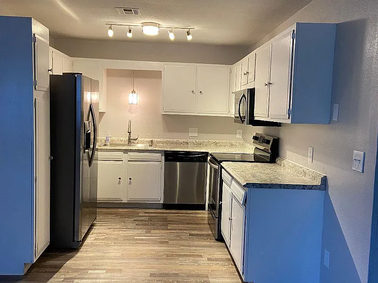 Impressive kitchen with new countertops, track, spot and pendant lighting, single deep sink with gooseneck faucet; and beautiful stainless appliances.