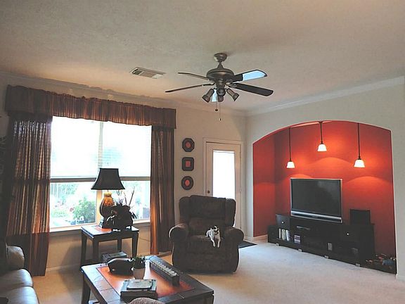 Over sized and beautifully  decorated living area showcases entertainment niche with custom lighting.