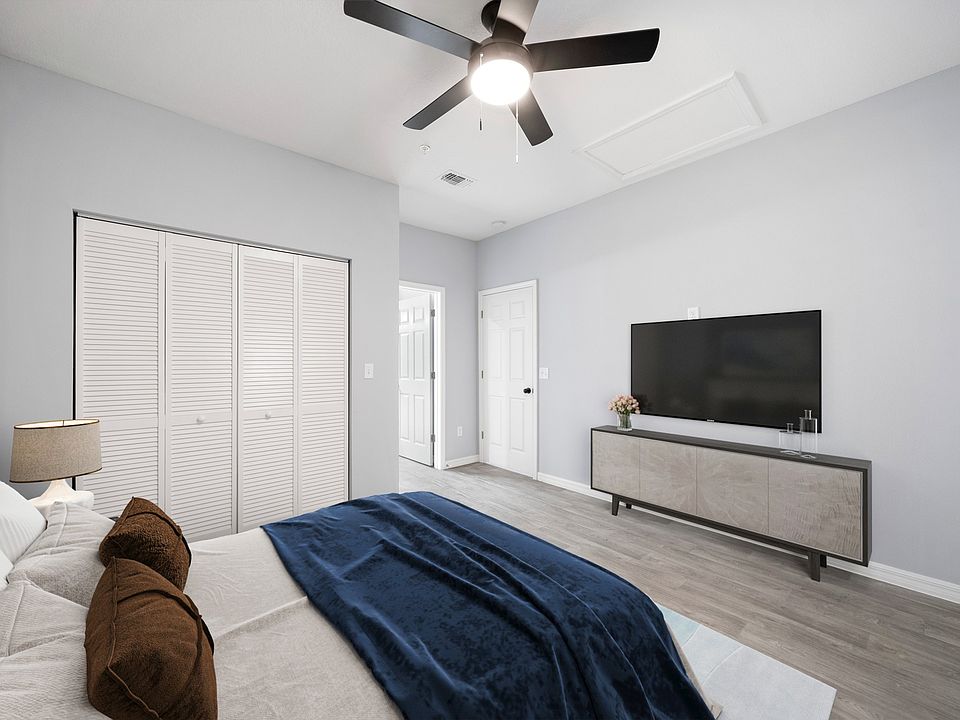 Master bedroom with a fan and closet, bed, tv on console in view