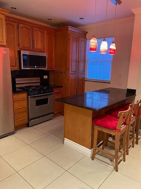 Kitchen with gas stove/range and granite countertop. Washer/Dryer inside large cabinet in rear.