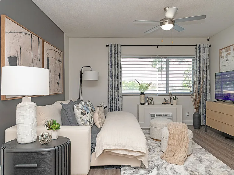 Spacious open living & sleeping area with hardwood-style flooring & ceiling fan