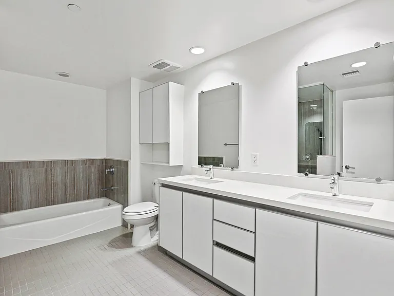 Large Bathroom with Full-Size Bathtub , a Double-Sink Vanity, and Cabinet Storage