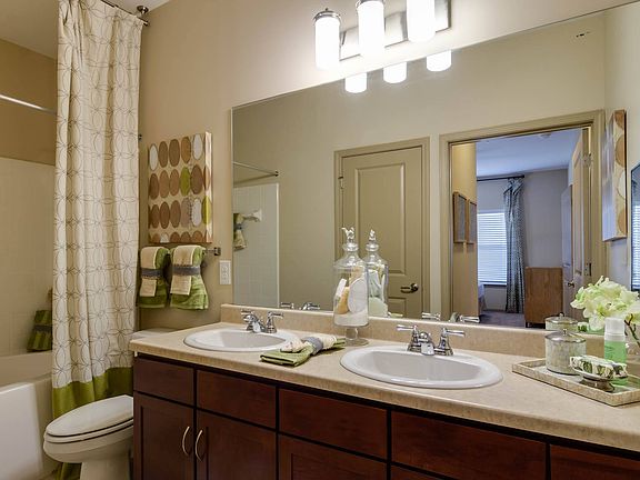 Model bathroom featuring a convienient double vanity and large scale mirror for viewing