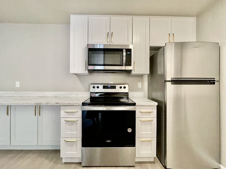 Designer kitchen with solid wood cabinets, quartz counterops, and stainless appliances