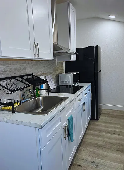 Bright kitchen with fridge, microwave, and essential amenities