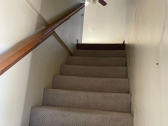Stairs from front door to living room. Ample storage on both sides of the stairs.