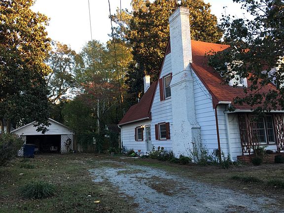 Side of house with view of small open barn