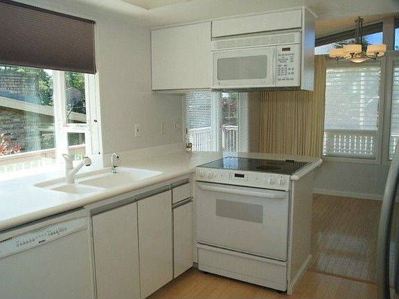 The kitchen has Corian counter tops, garden window, newer laminate flooring, newly painted walls and
