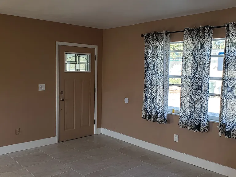 View of Living Area and Front Entry Door from Hallway.