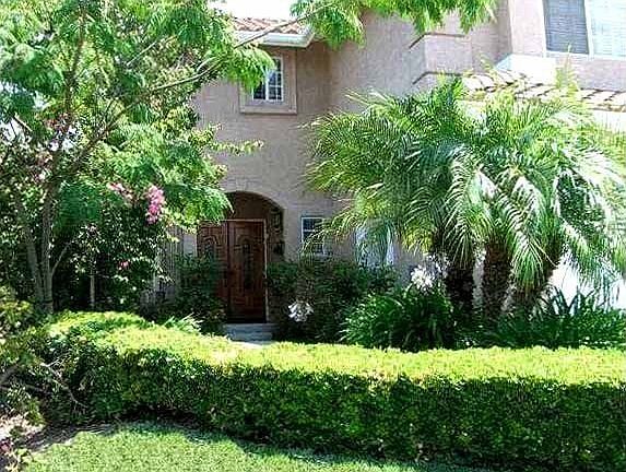 Mature landscaping and a double door entry