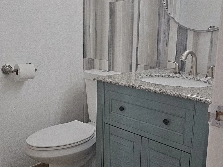 Stylish guest bathroom featuring updated vanity and dual access, ideally positioned near the entry and connected to the laundry area for everyday convenience.