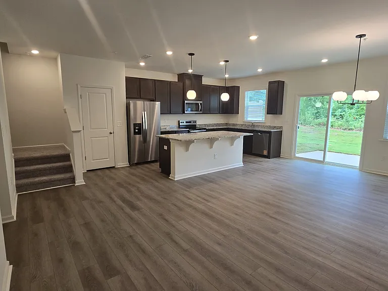 Open layout with large island kitchen, sliding door to the back porch, appliances, kitchen pantry