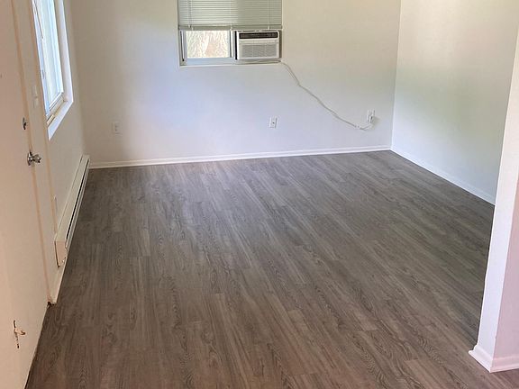 View of living room from kitchen. Unit is freshly painted and has brand new flooring throughout.