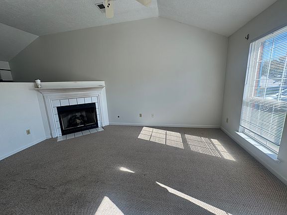 Step into a bright and airy living space. Featuring soaring high ceilings, an abundance of natural light, and a cozy working fireplace, this living room is perfect for relaxing evenings or entertaining guests.