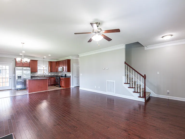 Living room features hardwood floors, a gas fireplace and a heavy-duty TV mount compatible with 42"_90" TVs supporting up to 150 lbs.