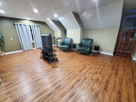 Private living room area with chairs and wood desk. TV stand only.