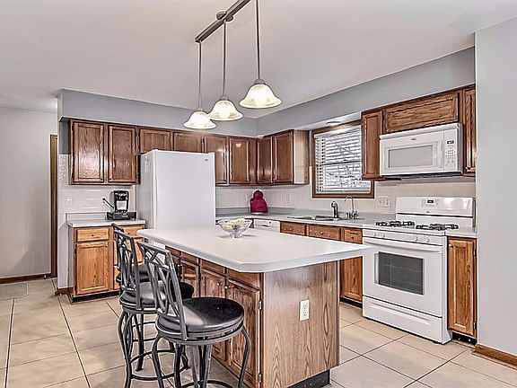 KITCHEN FEATURES CERAMIC FLOORING, SNACK BAR ISLAND, BACKSPLASH AND ALL THE APPLIANCES