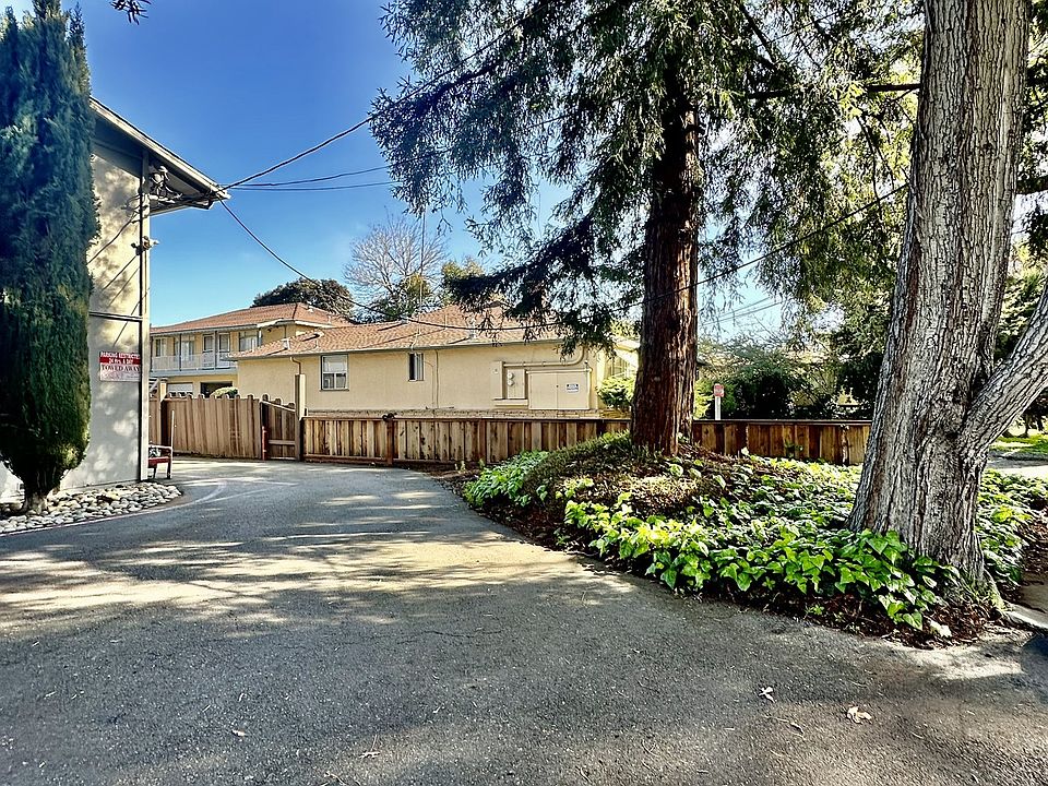 a house with a driveway and trees in front of it